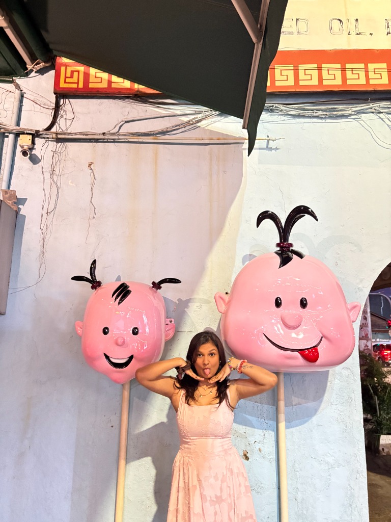 Portrait beside a pair of playful pink character statues.